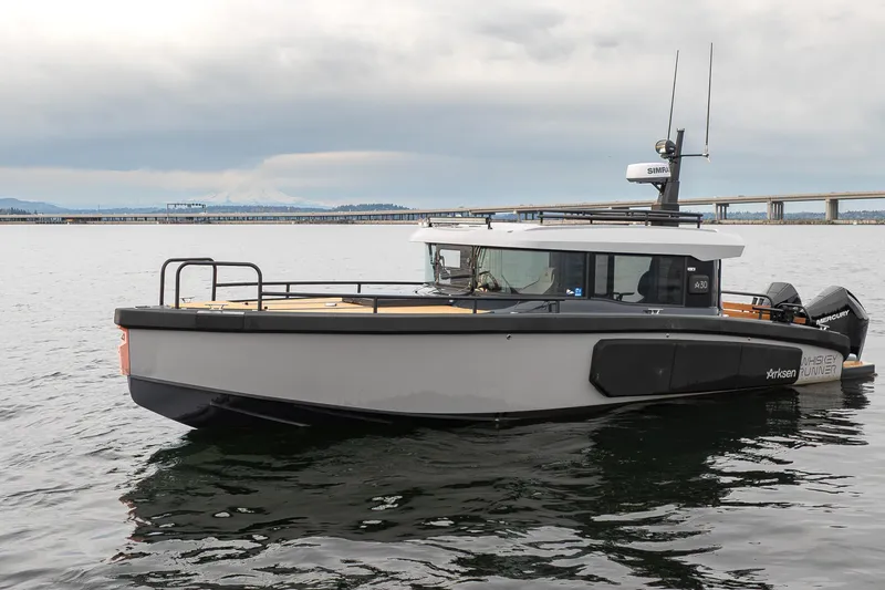 Slide: The Image of 2023 Arksen 30 Adventure boat on calm water, with a bridge in the background. - 25