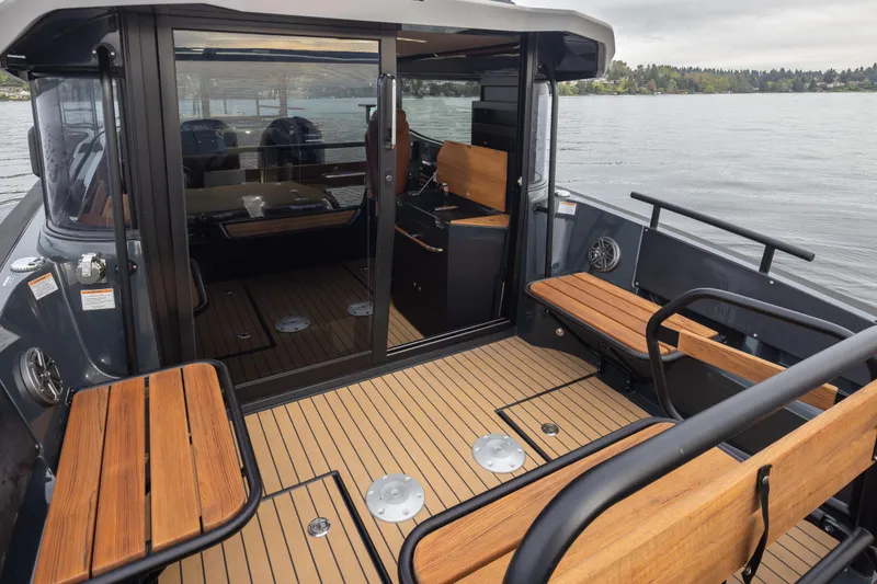 Slide: The Image of 2023 Arksen 30 Adventure boat interior with wooden seating and sleek design on a calm lake. - 27