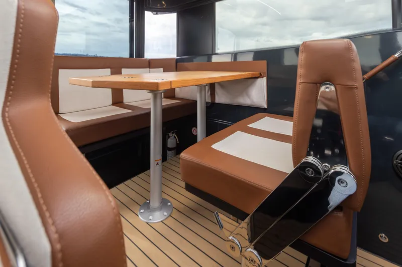 Slide: The Image of Interior of 2023 Arksen 30 Adventure boat with brown leather seating and wooden table. - 6