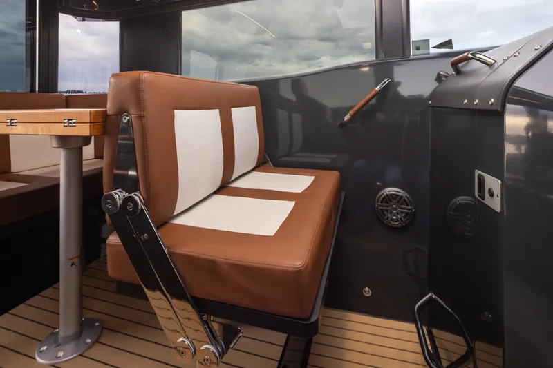 Slide: The Image of Interior of 2023 Arksen 30 Adventure boat with brown seating and wooden table. - 7