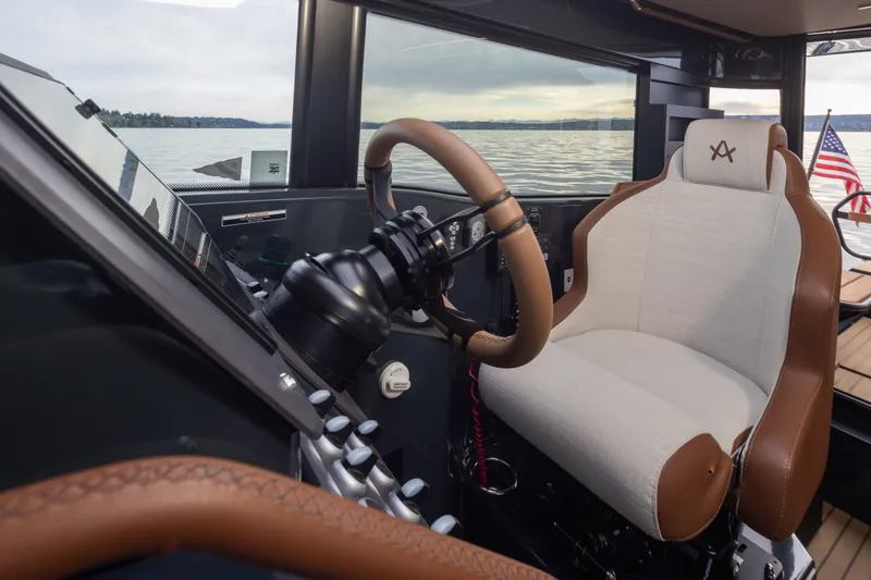 Slide: The Image of Interior of 2023 Arksen 30 Adventure boat, featuring a luxurious captain's seat and steering wheel. - 8