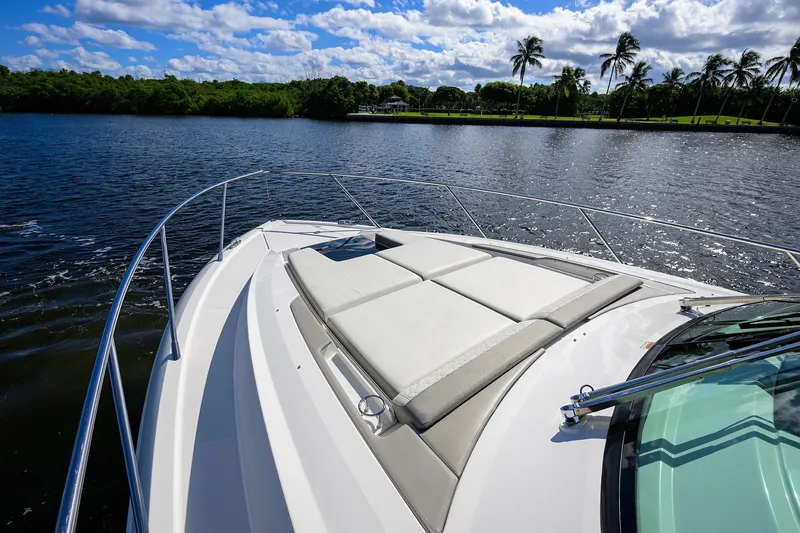 Slide: The Image of 2022 Tiara Yachts 43 LE on serene water with sunpad and palm trees. - 19