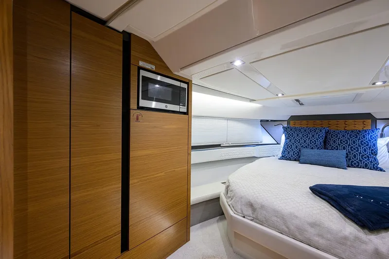 Slide: The Image of Luxurious 2022 Tiara Yachts 43 LE cabin interior with modern wood paneling and cozy bedding. - 42