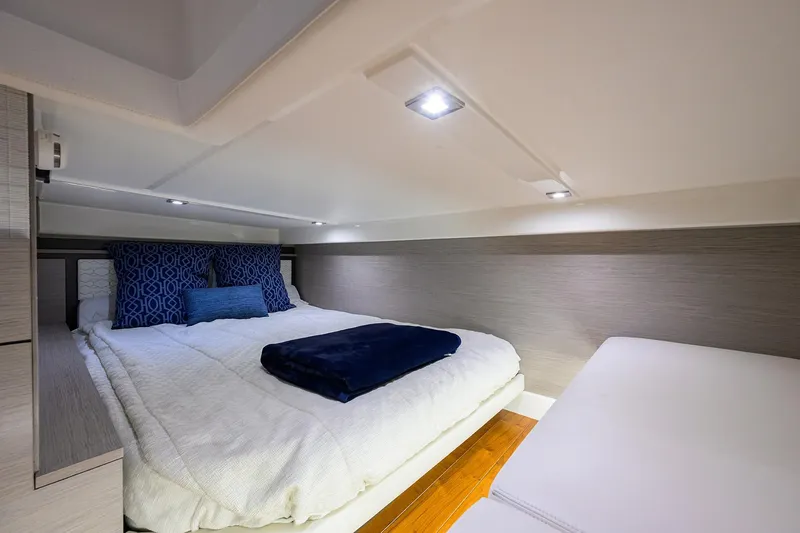 Slide: The Image of Luxurious cabin interior of 2022 Tiara Yachts 43 LE with cozy bedding and modern lighting. - 44