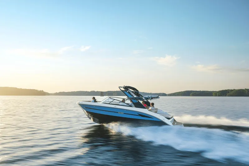 Slide: The Image of 2026 Sea Ray SDX 250 Surf cruising on serene waters at sunset. - 1
