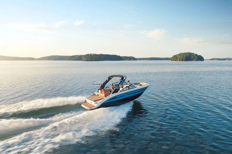 Slide: The Image of 2026 Sea Ray SDX 250 Surf cruising on calm waters at sunset. - 2