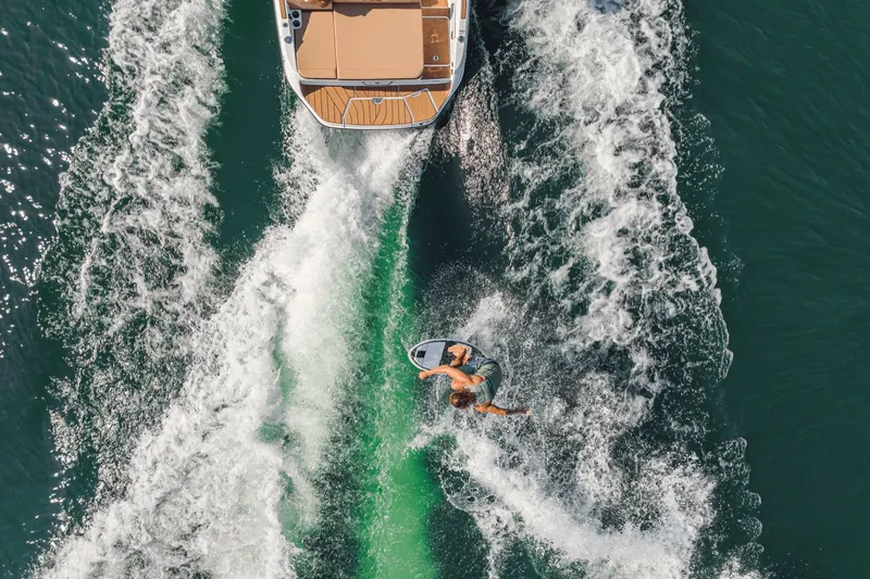 Slide: The Image of Aerial view of surfer behind a Sea Ray SDX 250 Surf boat. - 9