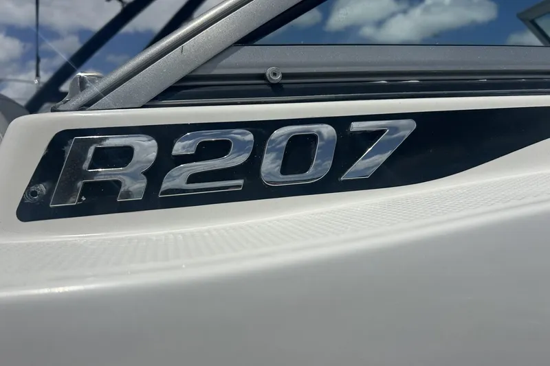Slide: The Image of 2014 Robalo R207 Dual Console boat emblem with sky background. - 19