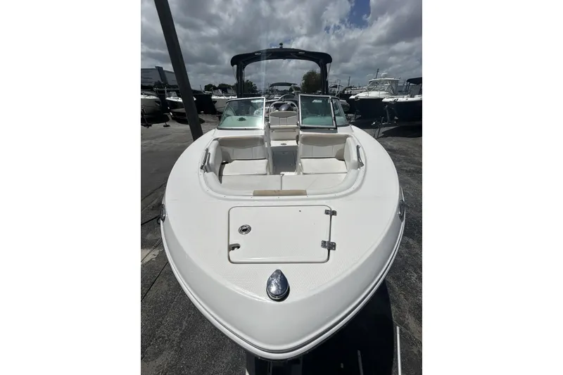 Slide: The Image of 2014 Robalo R207 Dual Console boat with open bow seating, docked under cloudy skies. - 7
