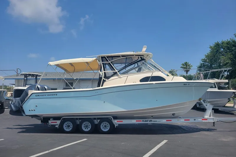 The Image of 2023 Grady-White Marlin 300 boat on trailer under clear blue sky. - 0