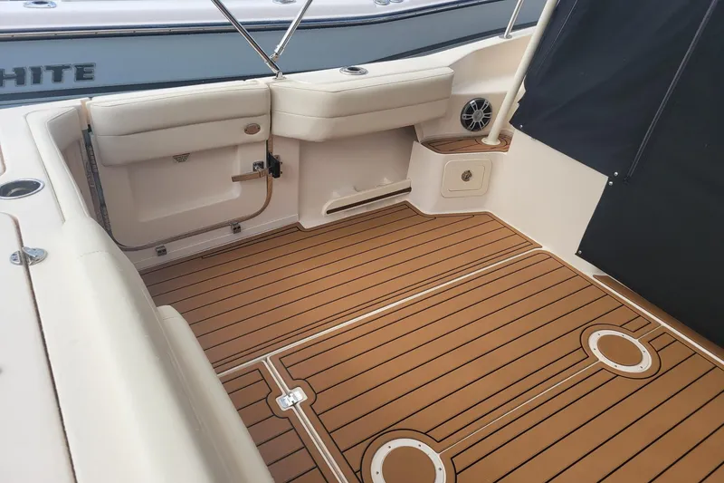 Slide: The Image of 2023 Grady-White Marlin 300 boat interior with teak flooring and cushioned seating. - 11