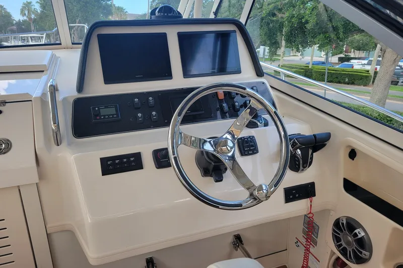 Slide: The Image of 2023 Grady-White Marlin 300 helm with modern controls and dual displays. - 19