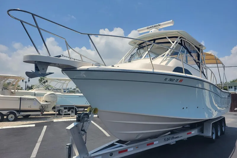 Slide: The Image of 2023 Grady-White Marlin 300 boat on trailer under clear sky. - 2