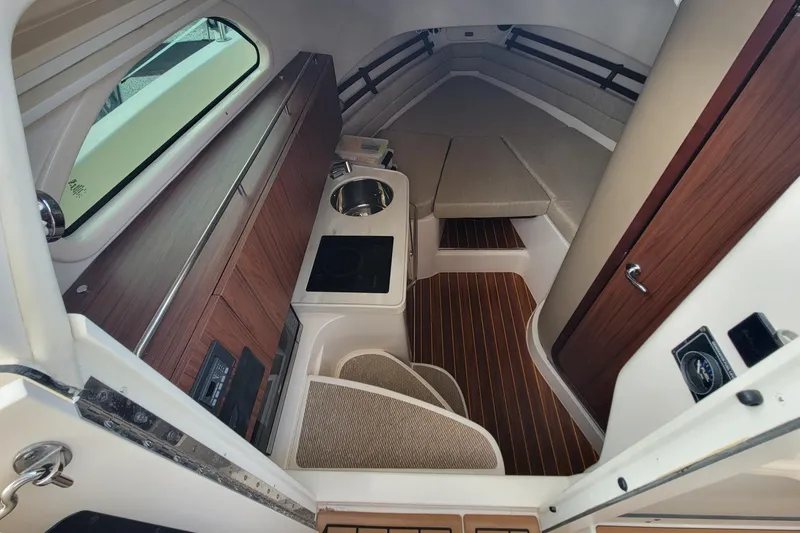 Slide: The Image of 2023 Grady-White Marlin 300 cabin interior with kitchenette and seating area. - 22
