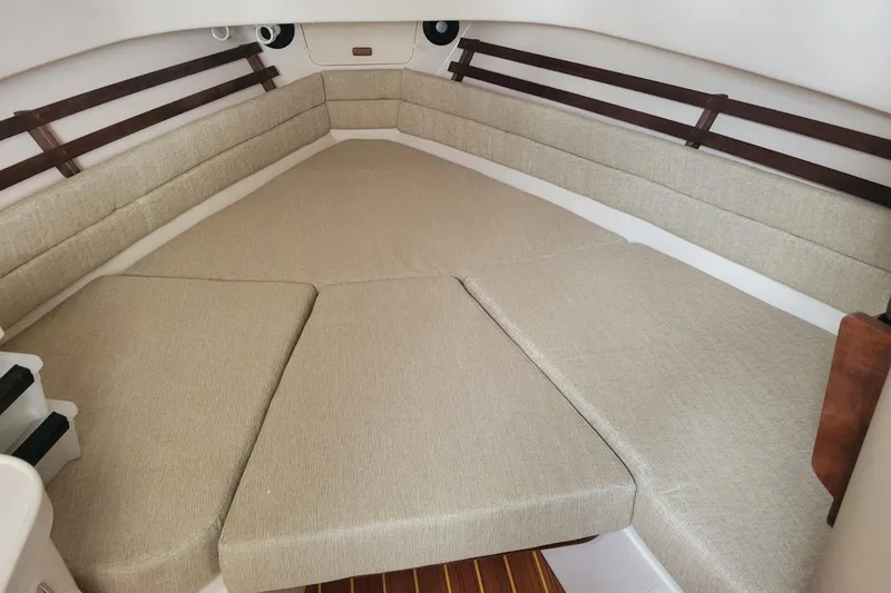 Slide: The Image of 2023 Grady-White Marlin 300 cabin interior with beige cushions and wooden accents. - 23
