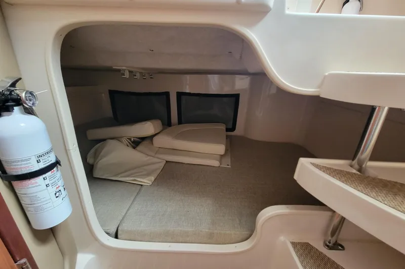 Slide: The Image of 2023 Grady-White Marlin 300 cabin interior with cushions and fire extinguisher. - 26