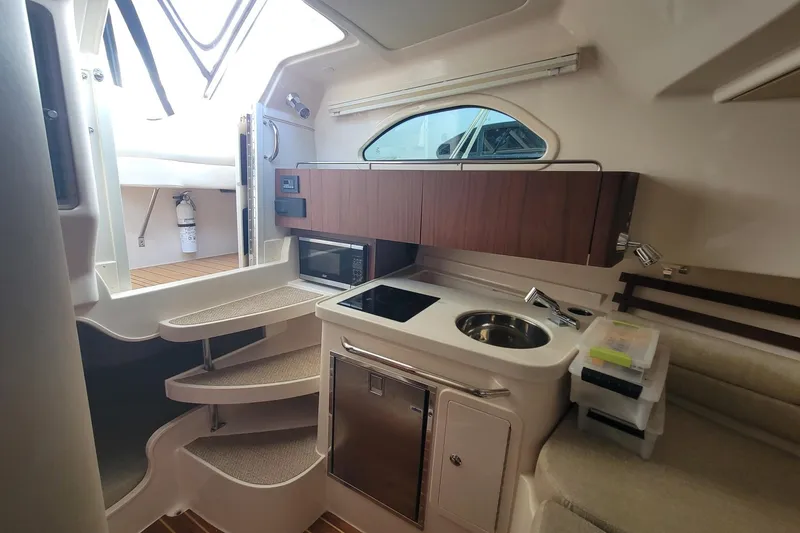 Slide: The Image of 2023 Grady-White Marlin 300 cabin interior with kitchenette and stairs. - 27