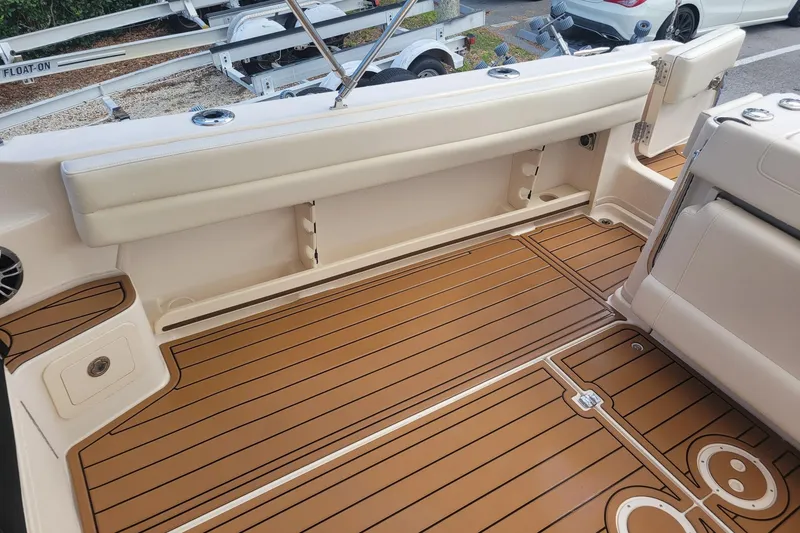 Slide: The Image of 2023 Grady-White Marlin 300 boat interior with teak-style flooring and cushioned seating. - 9