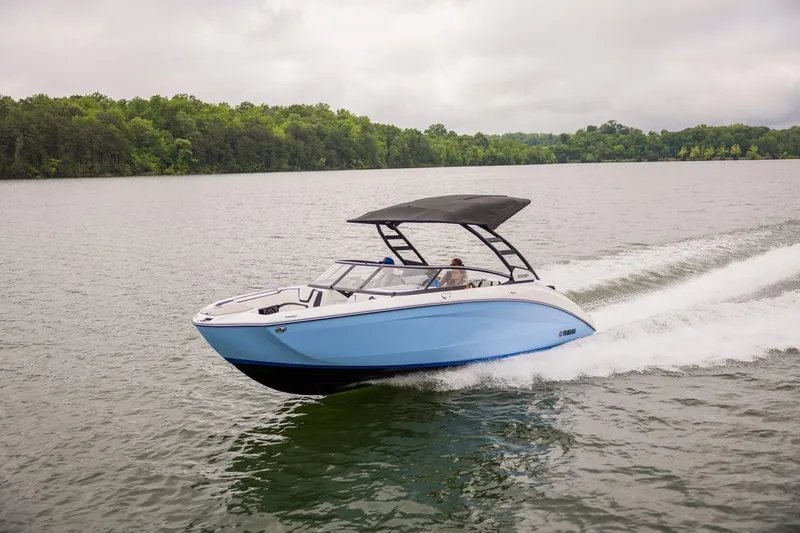 Slide: The Image of 2026 Yamaha Boats 252SD cruising on a serene lake with lush green shoreline. - 14