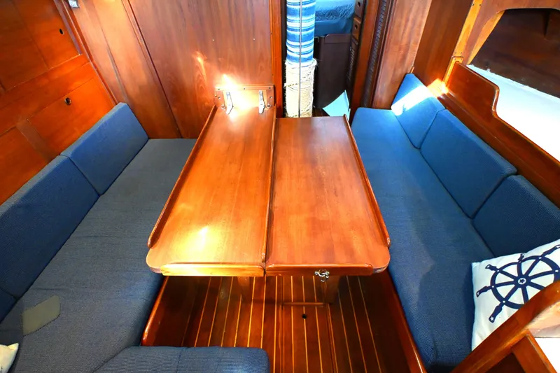 Slide: The Image of Interior of 1980 Tartan 37 sailboat with wooden table and blue cushioned seating. - 44