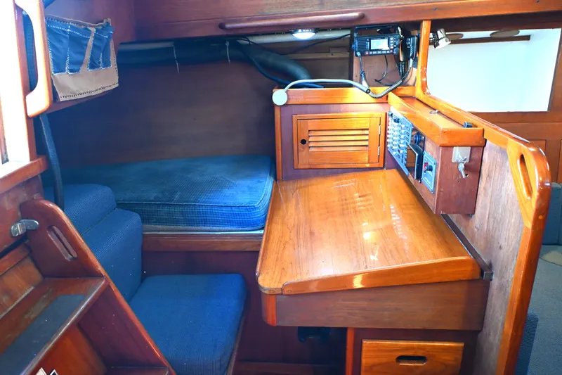 Slide: The Image of Cozy 1980 Tartan 37 sailboat interior with wooden desk and blue cushions. - 36