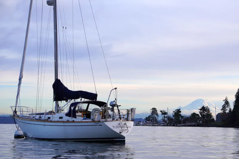Slide: The Image of 1980 Tartan 37 sailboat on calm water with mountain backdrop. - 1