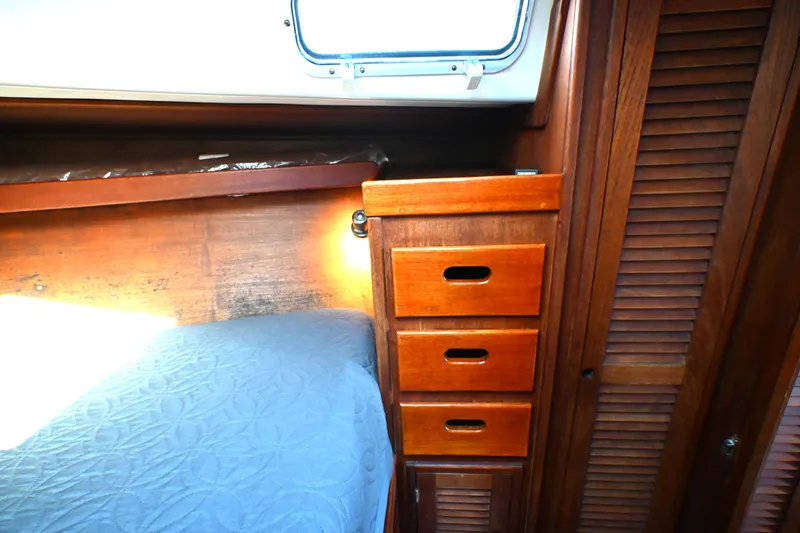 Slide: The Image of Interior of a 1980 Tartan 37 sailboat with wooden drawers and blue bedding. - 47