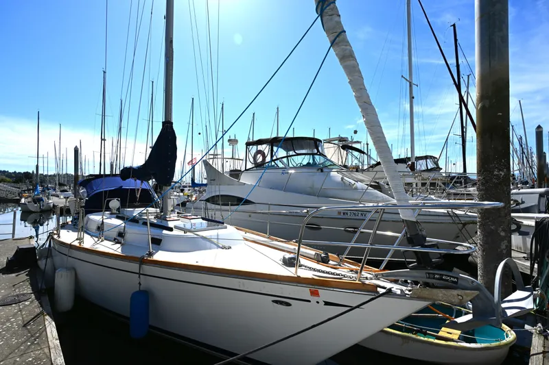 Slide: The Image of 1980 Tartan 37 sailboat docked in a marina under a clear blue sky. - 4