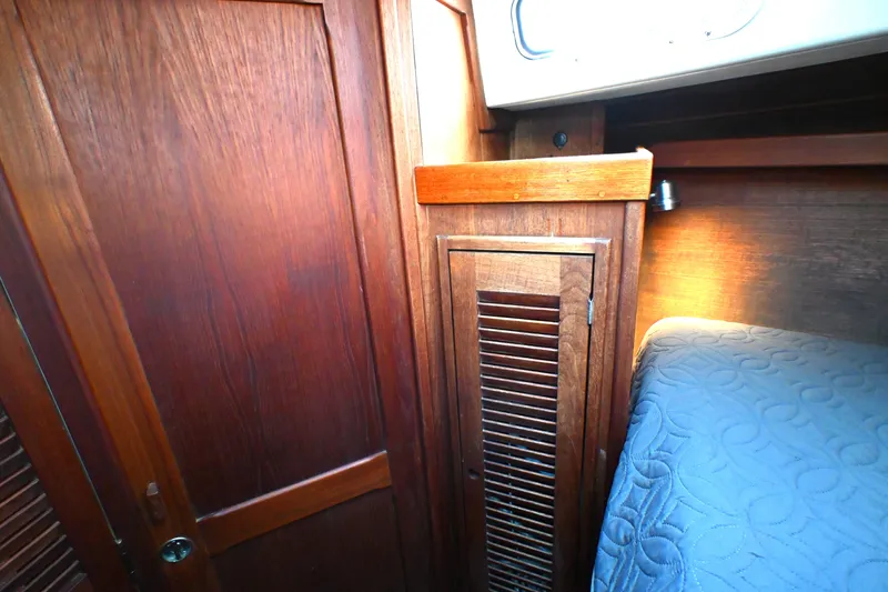 Slide: The Image of Interior of 1980 Tartan 37 sailboat with wooden cabinetry and cozy bedding. - 49