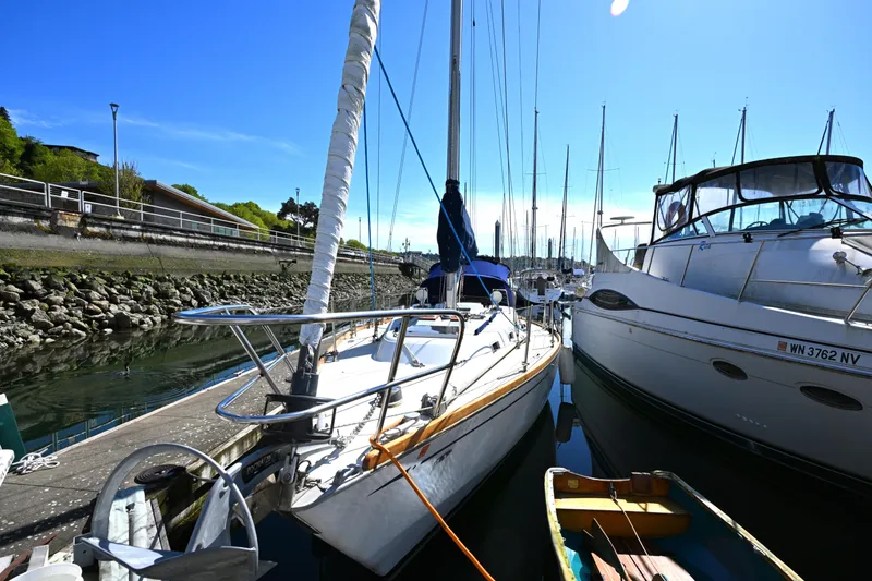 Slide: The Image of 1980 Tartan 37 sailboat docked beside other boats in a sunny marina. - 3