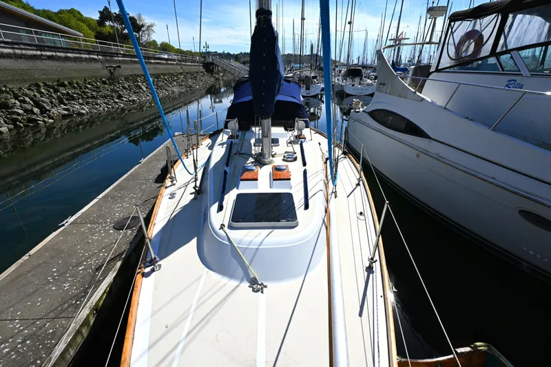 Slide: The Image of 1980 Tartan 37 sailboat docked in a marina, surrounded by other boats. - 8