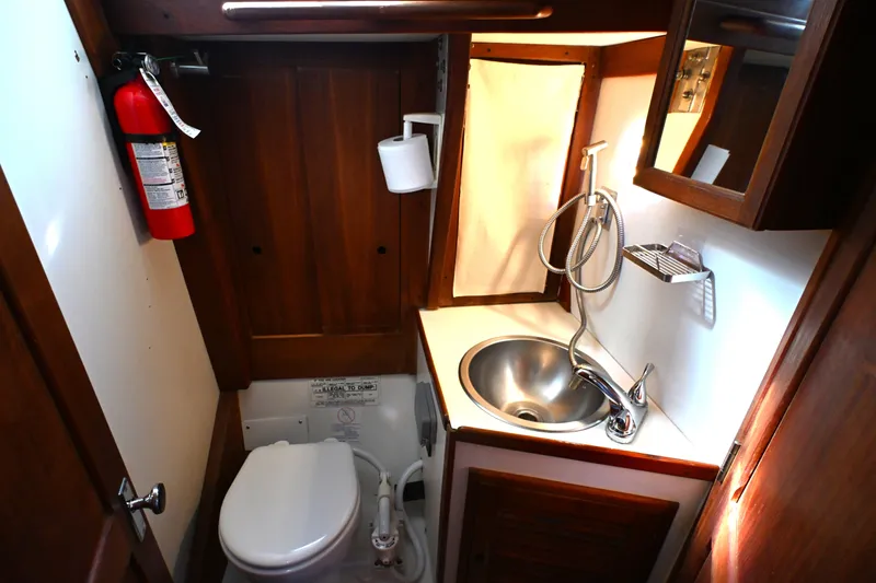 Slide: The Image of Compact bathroom in a 1980 Tartan 37 sailboat with sink, toilet, and fire extinguisher. - 51