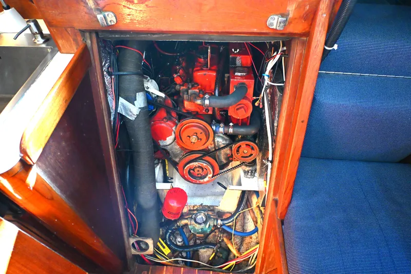 Slide: The Image of Engine compartment of a 1980 Tartan 37 sailboat, showcasing mechanical components and wiring. - 55