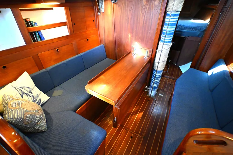 Slide: The Image of Interior of a 1980 Tartan 37 sailboat with wooden furnishings and blue seating. - 43