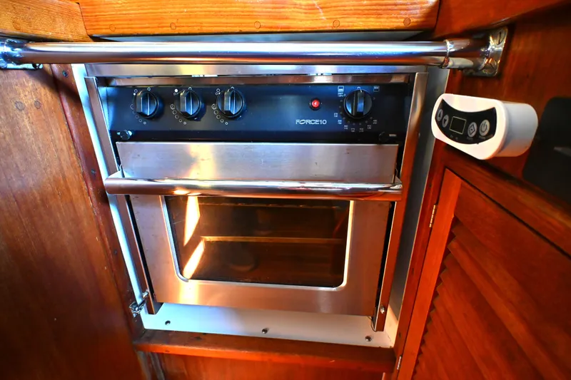 Slide: The Image of Stainless steel oven in a 1980 Tartan 37 yacht galley, featuring wooden cabinetry. - 34