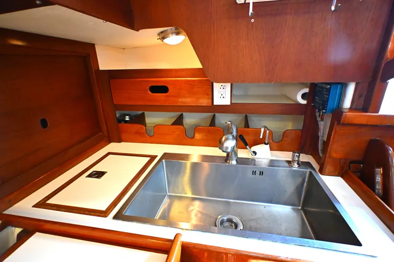 Slide: The Image of Galley sink area in 1980 Tartan 37 sailboat with wooden cabinetry. - 32