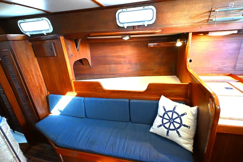 Slide: The Image of Interior of a 1980 Tartan 37 sailboat with wooden finish and blue cushions. - 42
