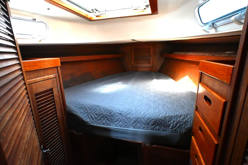 Slide: The Image of Cozy cabin interior of 1980 Tartan 37 sailboat with wooden furnishings and a comfortable bed. - 46