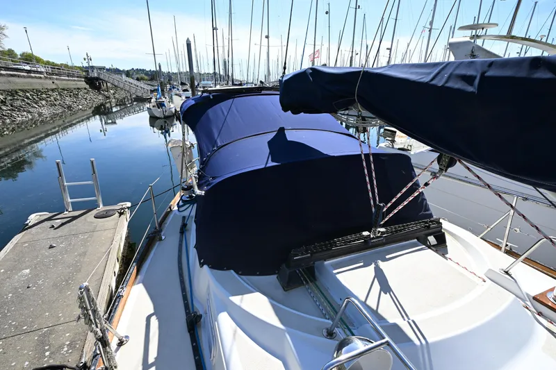 Slide: The Image of 1980 Tartan 37 sailboat docked in a marina, featuring blue covers and calm waters. - 16