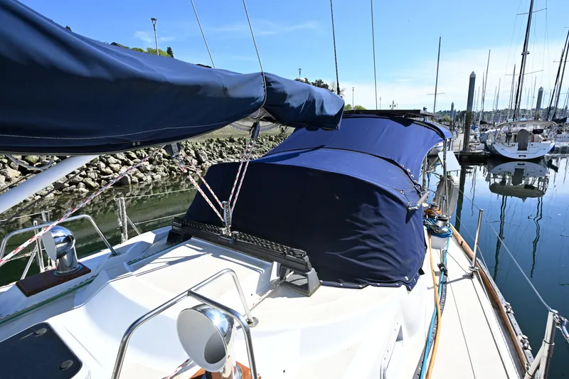 Slide: The Image of 1980 Tartan 37 sailboat docked in a marina, featuring blue canvas covers. - 17