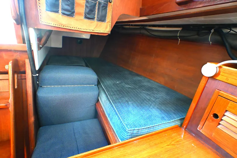 Slide: The Image of Interior cabin of a 1980 Tartan 37 sailboat with blue cushions and wooden finish. - 39