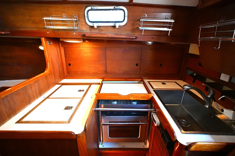 Slide: The Image of Vintage 1980 Tartan 37 yacht kitchen with wood cabinetry and modern appliances. - 31