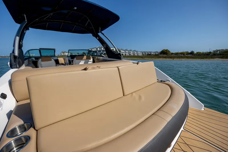 Slide: The Image of 2022 Sea Ray SLX 280 boat with tan seating, on calm water under clear blue sky. - 26