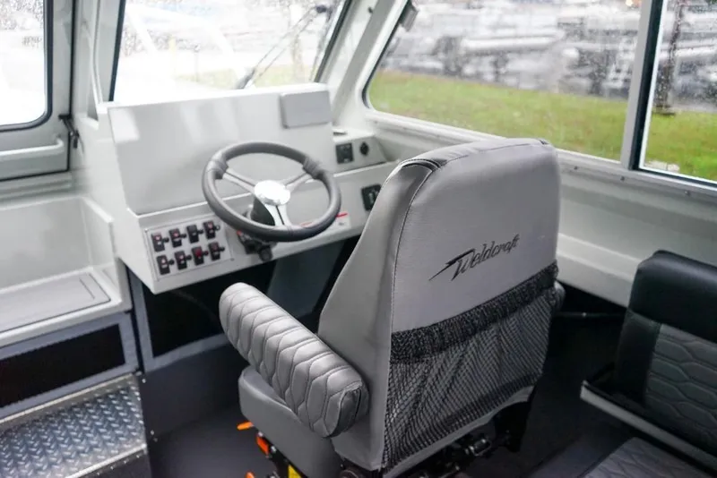 Slide: The Image of Interior of 2026 Weldcraft 220 Ocean King boat with steering wheel and captain's chair. - 15