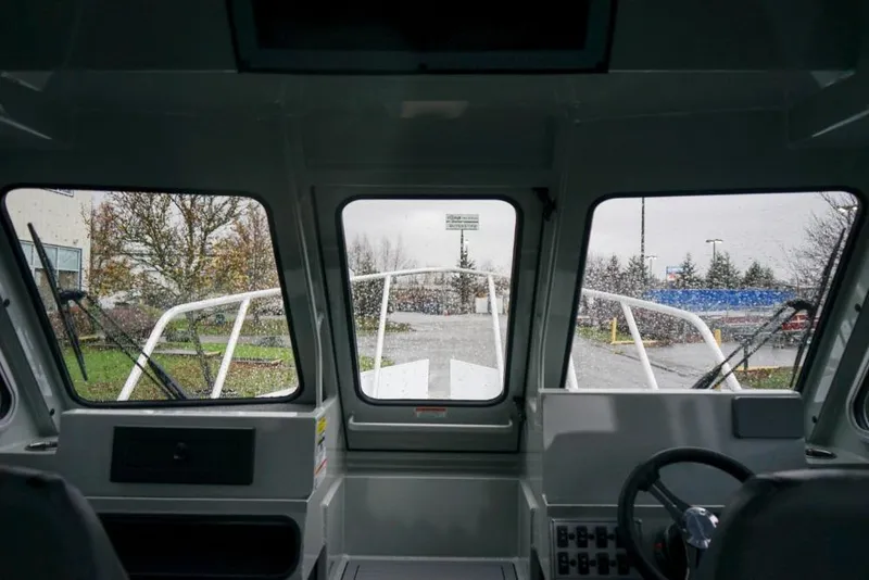 Slide: The Image of Interior view of 2026 Weldcraft 220 Ocean King boat, showcasing helm and windshield. - 16