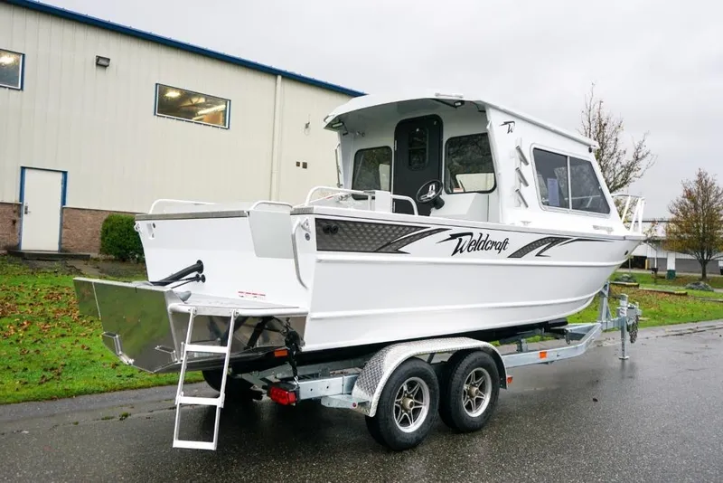 Slide: The Image of 2026 Weldcraft 220 Ocean King boat on trailer, parked outdoors near industrial building. - 4