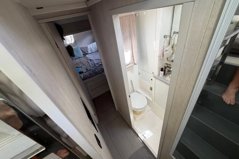 Slide: The Image of Interior of a 2017 Leopard 40 catamaran showing a compact bathroom and adjacent bedroom. - 109