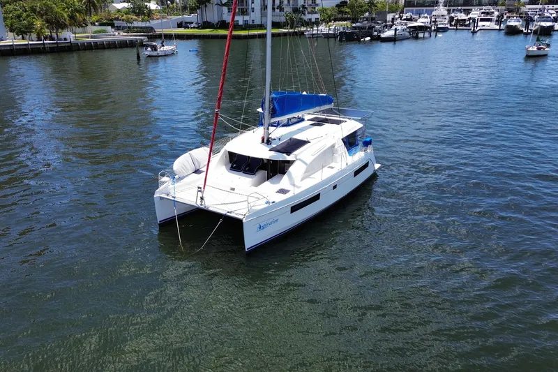 Slide: The Image of 2017 Leopard 40 catamaran sailing in a marina, surrounded by calm waters and docked boats. - 19