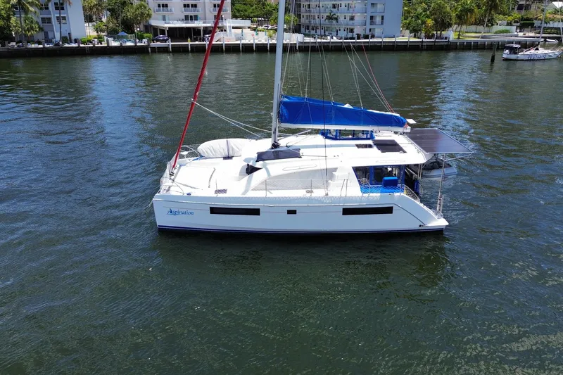 Slide: The Image of 2017 Leopard 40 catamaran on calm water, featuring blue sail and modern design. - 21
