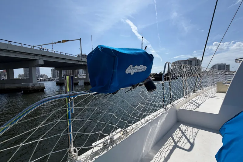 Slide: The Image of 2017 Leopard 40 catamaran docked near a bridge, featuring blue equipment cover. - 49